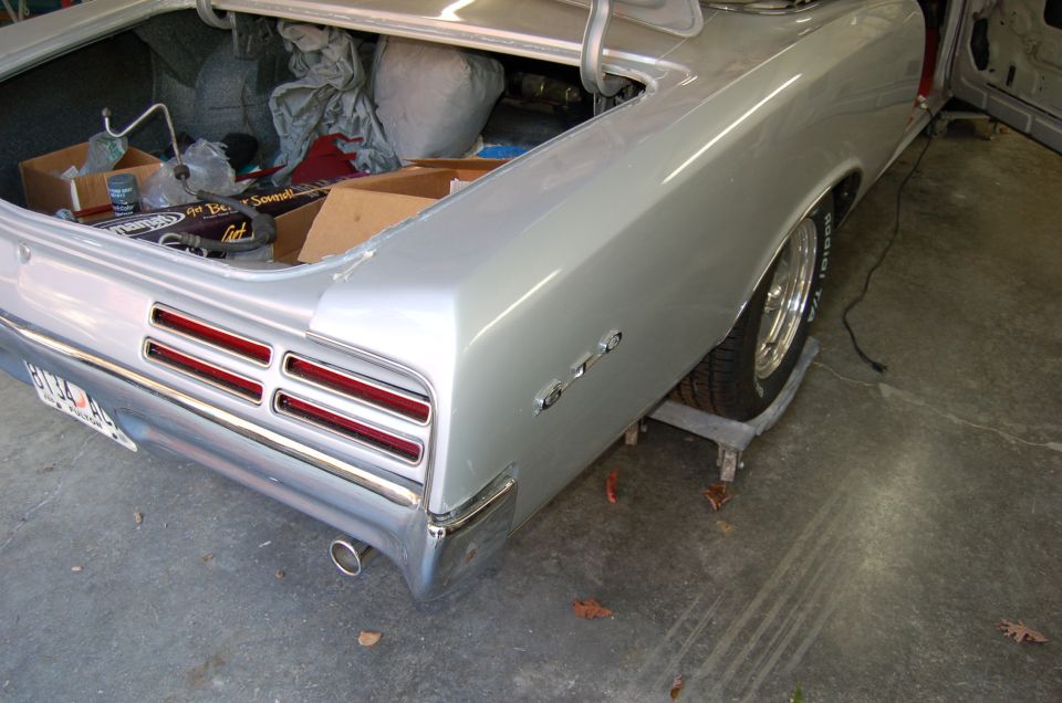 1967 Pontiac GTO rear quarter panel with GTO badge and stacked taillights, trunk open with contents