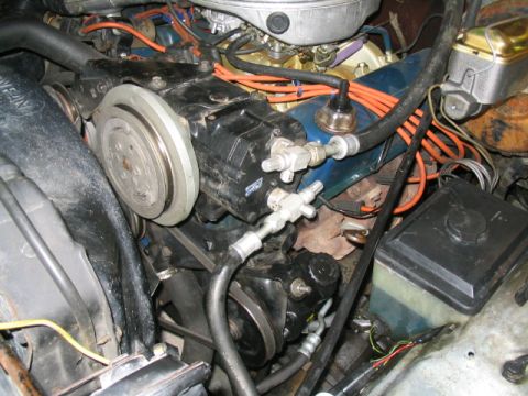1979 Ford Bronco - Close-up view of the engine compartment, focusing on the AC system components and associated wiring.