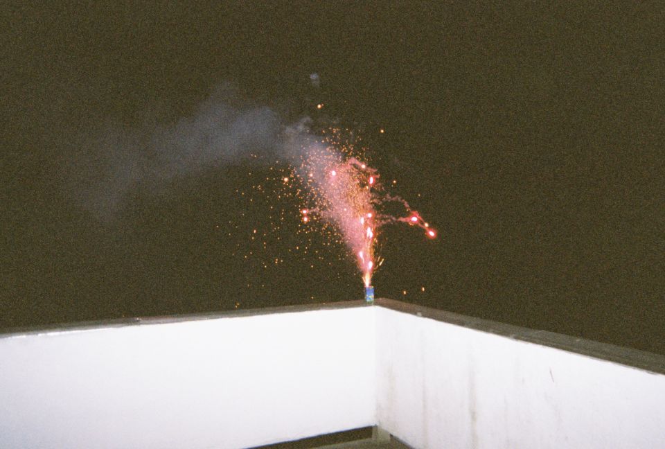 fireworks exploding on a rooftop at night