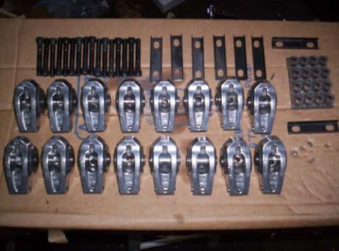 1990 Ford Mustang - A collection of engine components including rocker arms, bolts, and fasteners are laid out on cardboard.