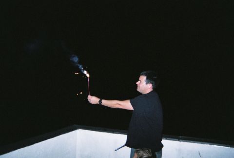 1990 Ford Bronco - A man holds a sparkler during a nighttime celebration.