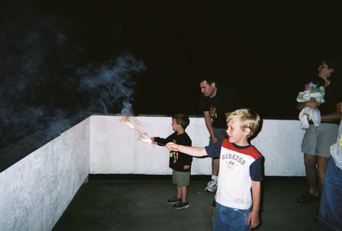 1990 Ford Bronco - Kids celebrate with sparklers on a balcony during a nighttime event.