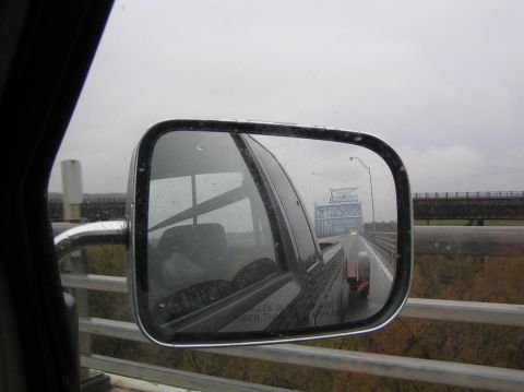 1997 Subaru Impreza - View of a bridge through a side mirror on a cloudy day, reflecting the road ahead.