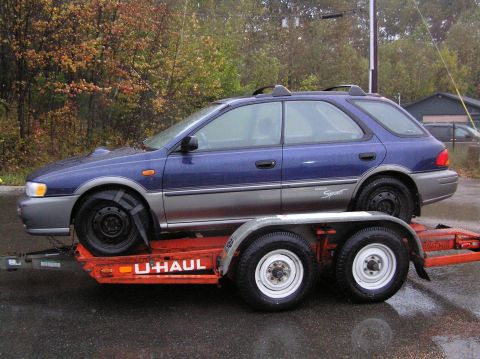 1997 Subaru Impreza - A blue 1997 Subaru Impreza wagon is seen being transported on a U-Haul trailer.