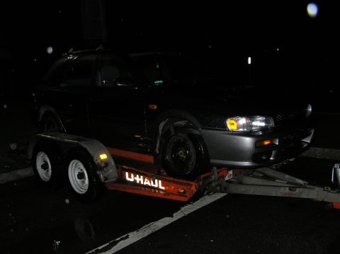 1997 Subaru Impreza - A 1997 Subaru Impreza is loaded onto a U-Haul trailer at night.