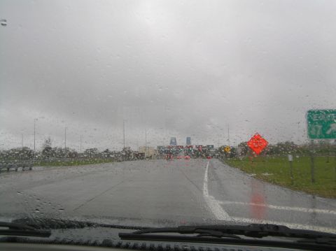 1997 Subaru Impreza - Approaching a toll plaza on a wet, overcast day, with raindrops visible on the glass.