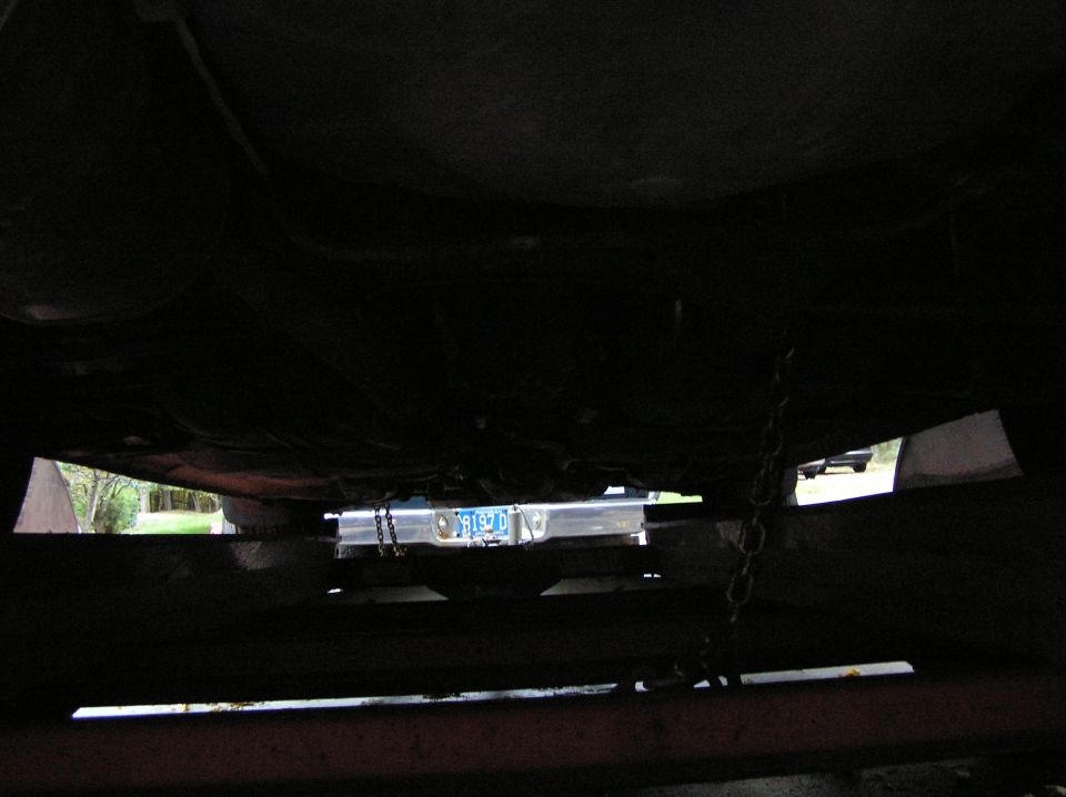 Underside view of a vehicle, showing a license plate that reads '9192 D'. Another vehicle is visible in the background