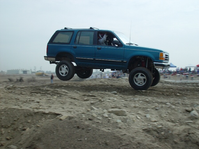 Blue SUV airborne, lifted suspension, off-road tires