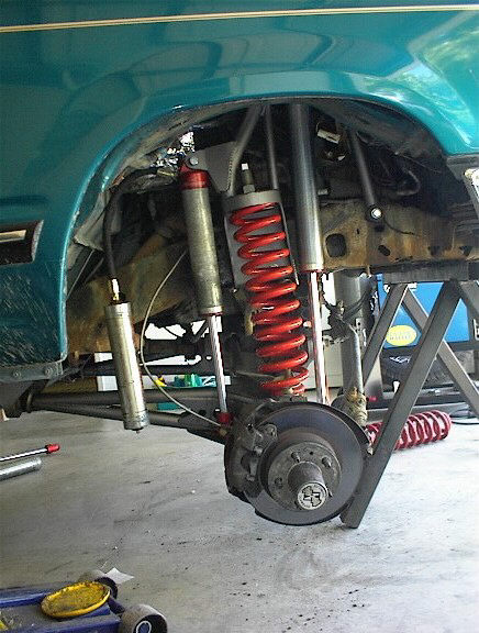 1984 Ford Bronco - Custom suspension components are visible on a teal vehicle, likely undergoing modifications.