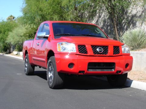 2005 Nissan Titan - Front view of a red 2005 Nissan Titan pickup truck parked on an asphalt surface.