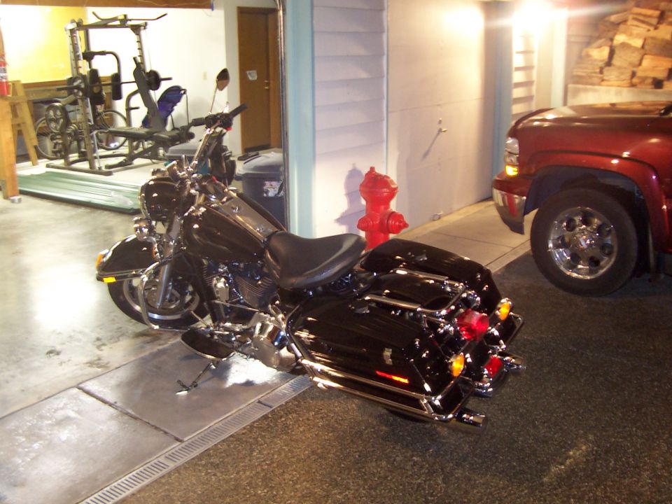 Black Harley-Davidson touring motorcycle parked indoors, rear view