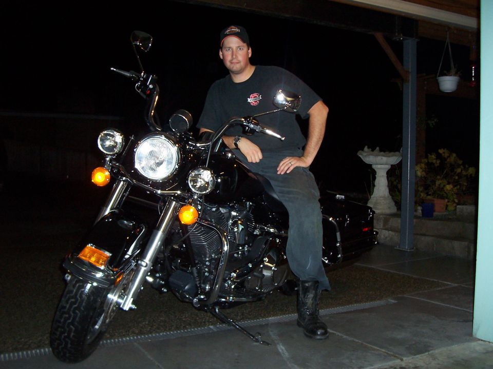 Man sitting on a black 2005 Harley-Davidson FLH motorcycle