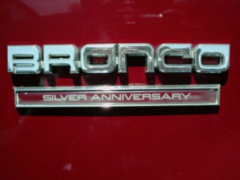 1994 Ford Bronco - Close-up of a red vehicle's rear emblem that reads 'Bronco Silver Anniversary'.