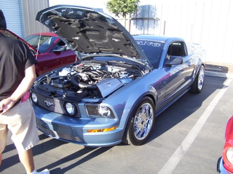 2002 Ford Mustang - Blue Ford Mustang with hood open, parked next to a red vehicle.