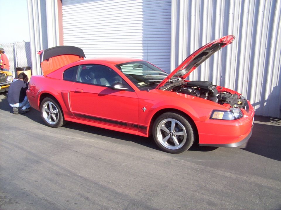 Red 2002 Ford Mustang with hood and trunk open