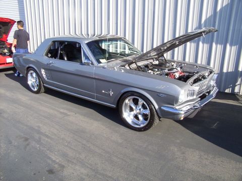 2002 Ford Mustang - Gray 1965 Ford Mustang coupe parked outdoors with its hood open, next to a red vehicle.