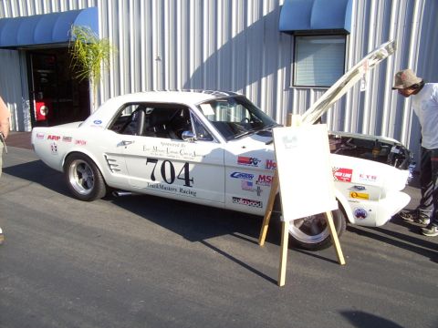 2002 Ford Mustang - This white 1965 Ford Mustang coupe displays racing decals and the number 704, suggesting it's a track car.