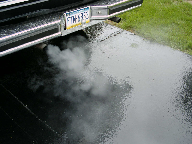 Rear bumper and exhaust pipe of a vehicle emitting smoke, license plate FTM-6853