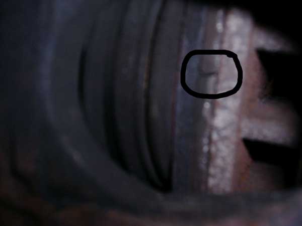 Close-up of a vehicle brake caliper, showing wear marks