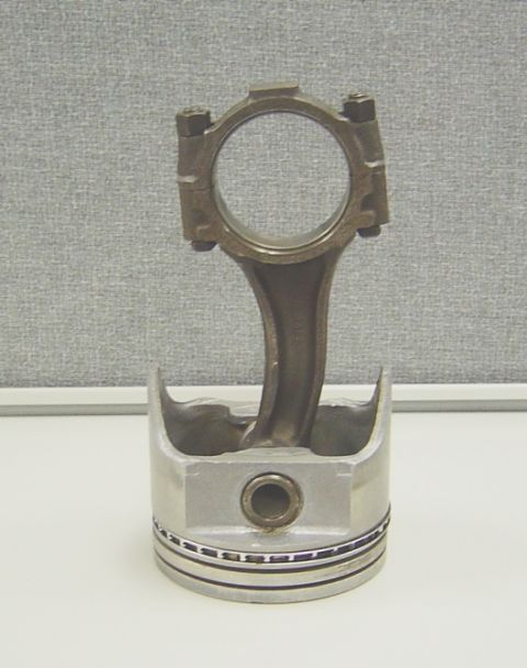 1986 Ford Bronco - A close-up view of a piston and connecting rod assembly, likely from an internal combustion engine.