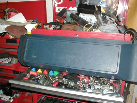 1979 Ford Bronco - A blue dashboard trim piece is placed on top of a red toolbox filled with various tools.