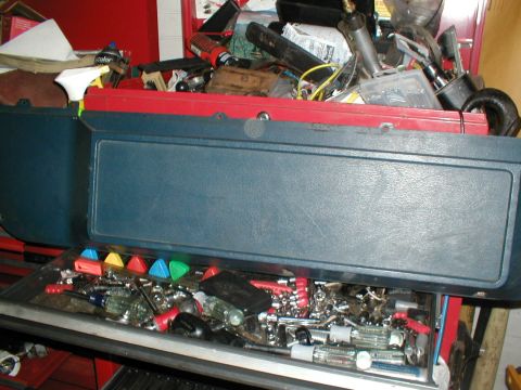 1979 Ford Bronco - A toolbox is open, revealing a collection of tools and supplies within its compartments.