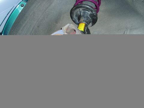 1993 Ford Taurus - A close-up view of a vehicle's suspension system, showing a shock absorber and coil spring.