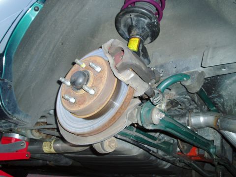 1993 Ford Taurus - Close-up view of a car's rear suspension system, showing the brake components and shock absorber.