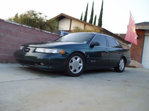 1993 Ford Taurus - This 1993 Ford Taurus sedan is captured in a three-quarter front view, parked on a concrete driveway.