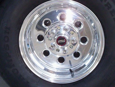 1992 Ford Crown Victoria - Head-on close-up of a polished Weld Racing drag wheel with red center cap, eight lightening holes and chrome lug nuts, mounted on a Mickey…