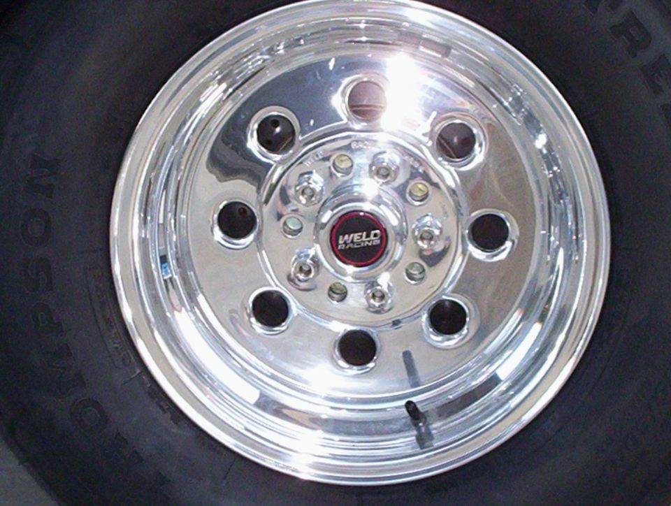 Polished Weld Racing drag wheel with red center cap on a Mickey Thompson tire