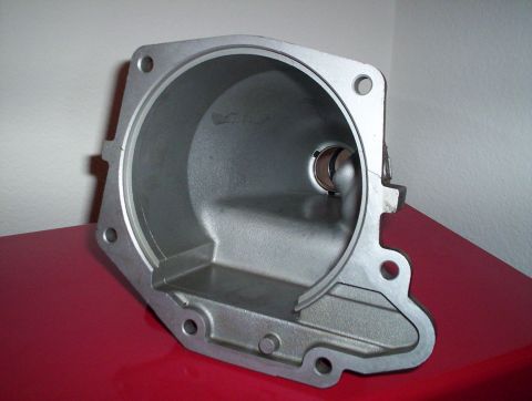 1992 Ford Crown Victoria - A metal transmission housing sits on a red surface against a white wall.