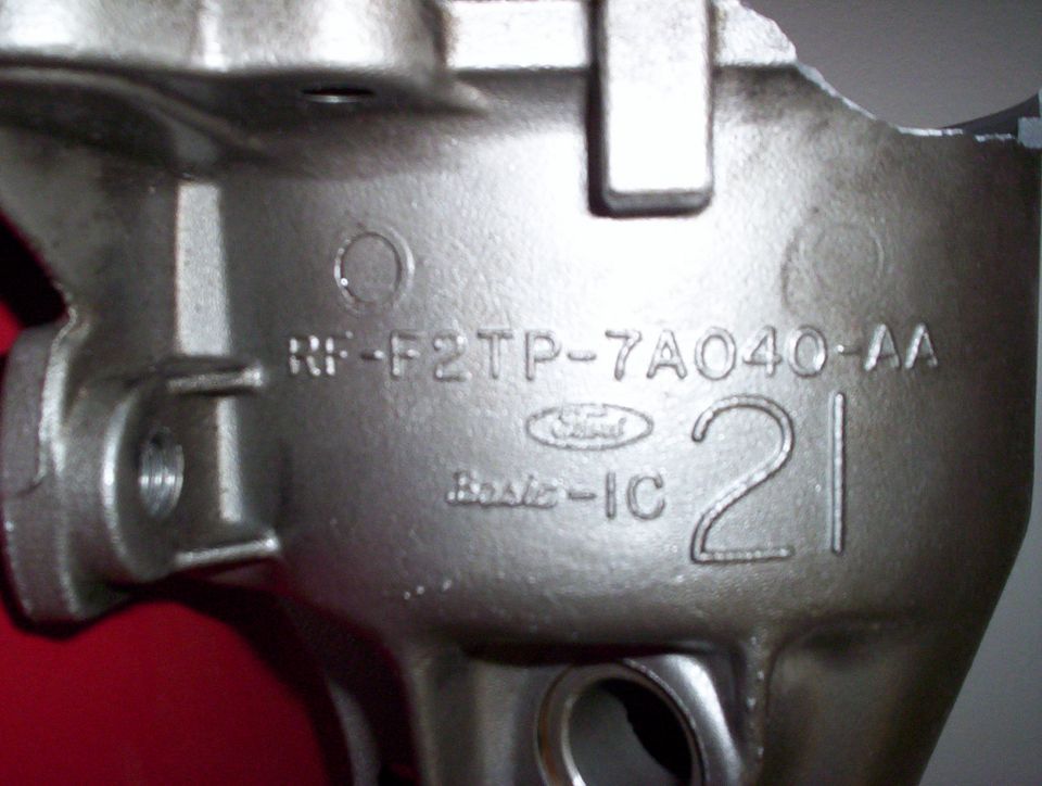 Metal engine part with Ford logo, part number RF-F2TP-7A040-AA, and casting date 21