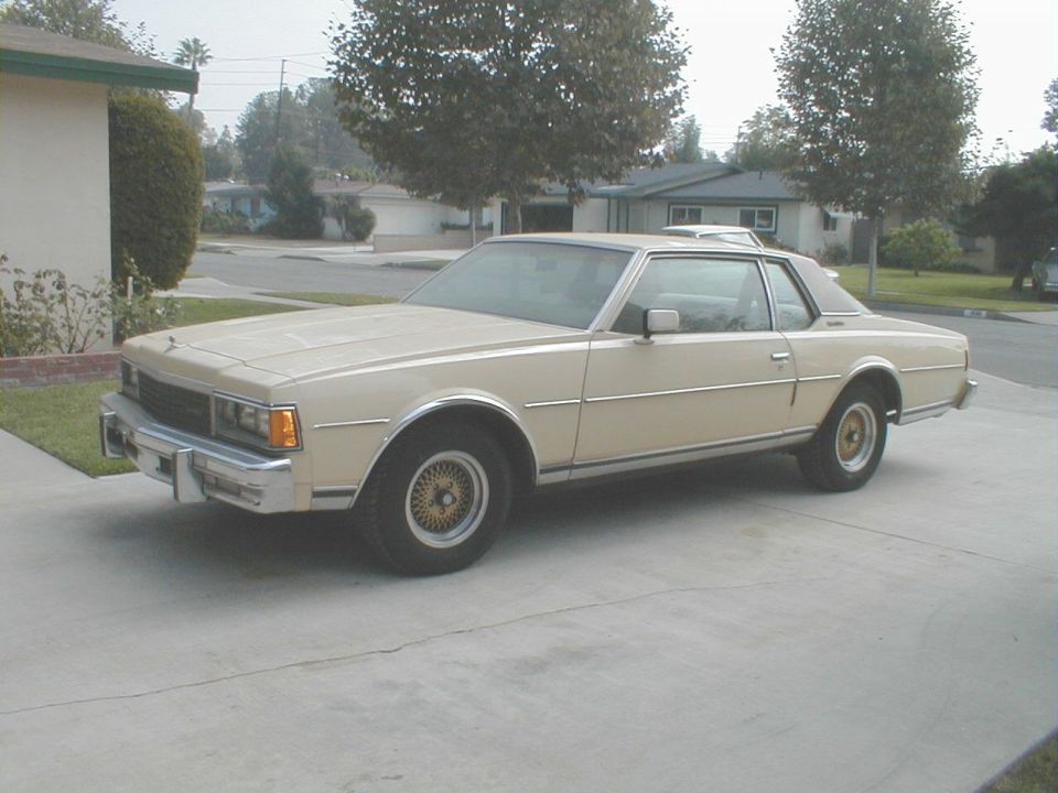 Cream Chevrolet Caprice coupe with landau roof and wire wheel covers in a driveway
