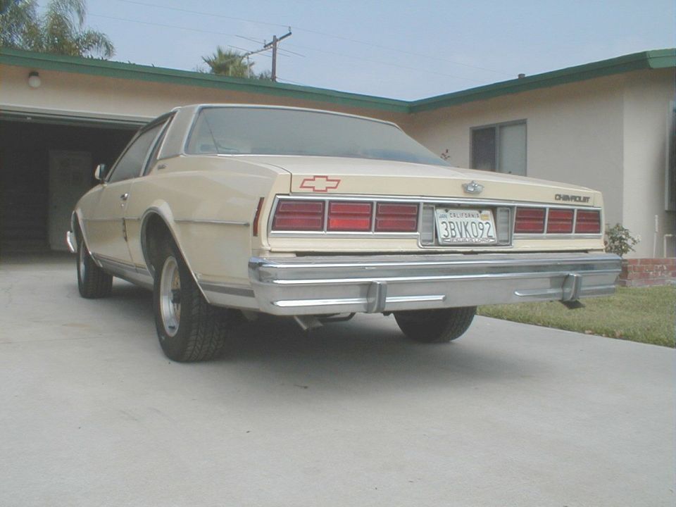 Rear view of tan Chevrolet Caprice coupe with California plate in driveway