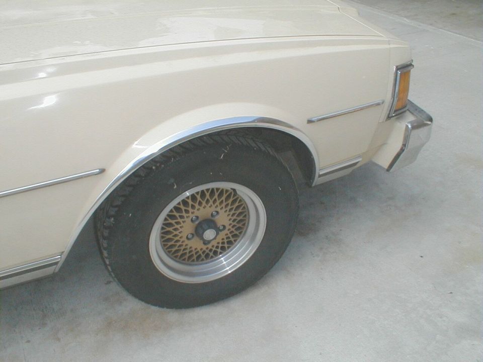 Front wheel of cream Chevrolet with gold mesh alloy wheel and chrome fender trim