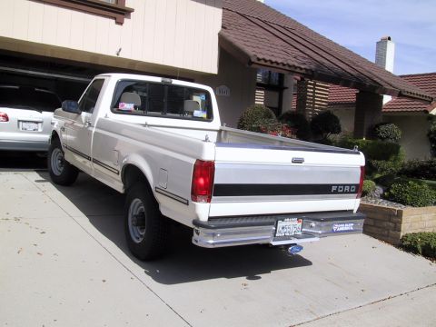 1992 Ford F-250 - Rear view of a white 1992 Ford F-250 pickup truck parked in a driveway next to a house.