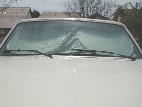 1992 Ford F-250 - The front of a white pickup truck is shown with a sunshade covering the windshield.