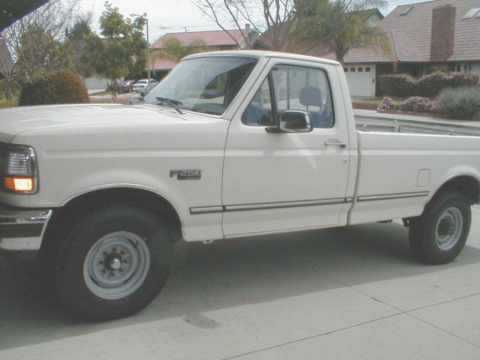 White 1992 Ford F-250 pickup truck, side view, showing F-250 badge on fender