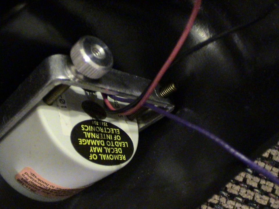 Close-up of an electronic component with wires and warning labels