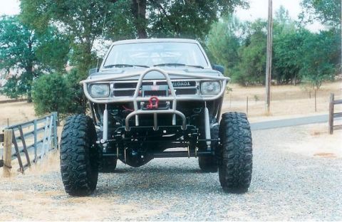 1991 Ford Bronco - This heavily modified Toyota truck features a custom front bumper, large off-road tires, and a visible roll cage.