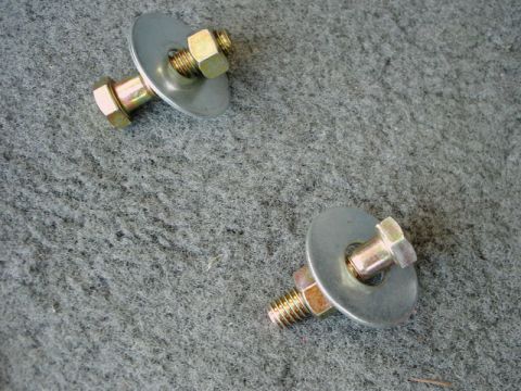 1984 Ford Bronco - Close-up of hardware components on a textured gray surface.