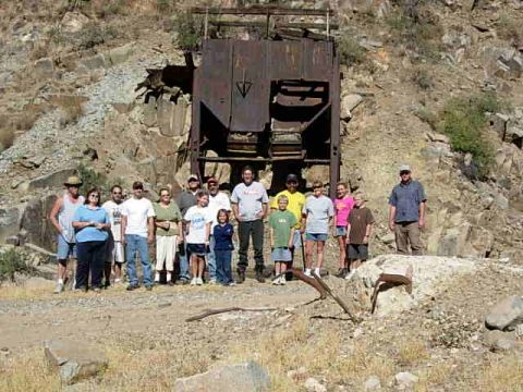 1981 Ford F-150 - A group of people pose for a photo in front of old mining equipment in a rocky, arid landscape.