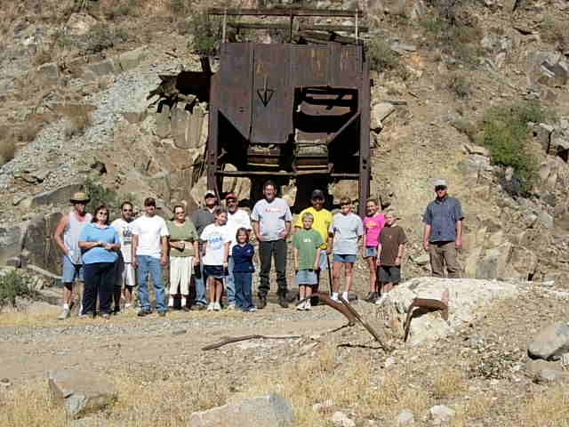 Group of people in front of abandoned mining equipment