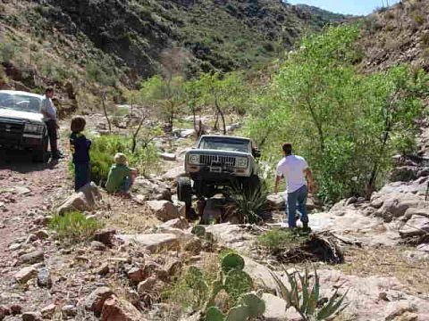 1981 Ford F-150 - Off-roading adventure in a , mountainous terrain with two vehicles and onlookers.