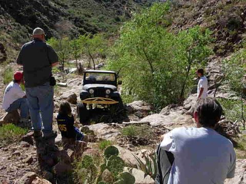 1981 Ford F-150 - A group of people observe a Jeep CJ-7 navigating a , rocky terrain in a canyon.