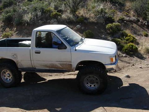 1981 Ford F-150 - A white pickup truck is parked on a dirt road in a dry, hilly area with sparse vegetation.