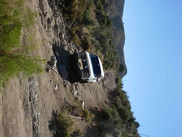 White pickup truck on a steep, rocky dirt road