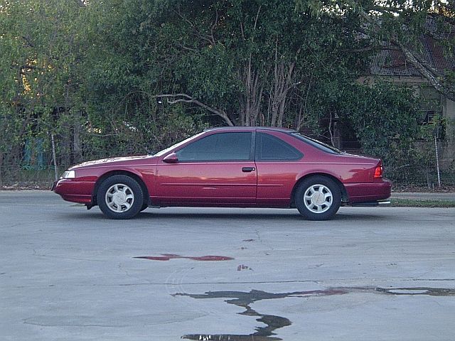 1994 Ford Thunderbird coupe, side view, red paint, tinted windows