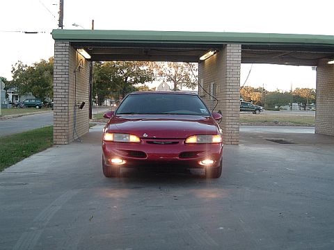 1994 Ford Thunderbird - Front view of a red 1994 Ford Thunderbird parked under a carport.